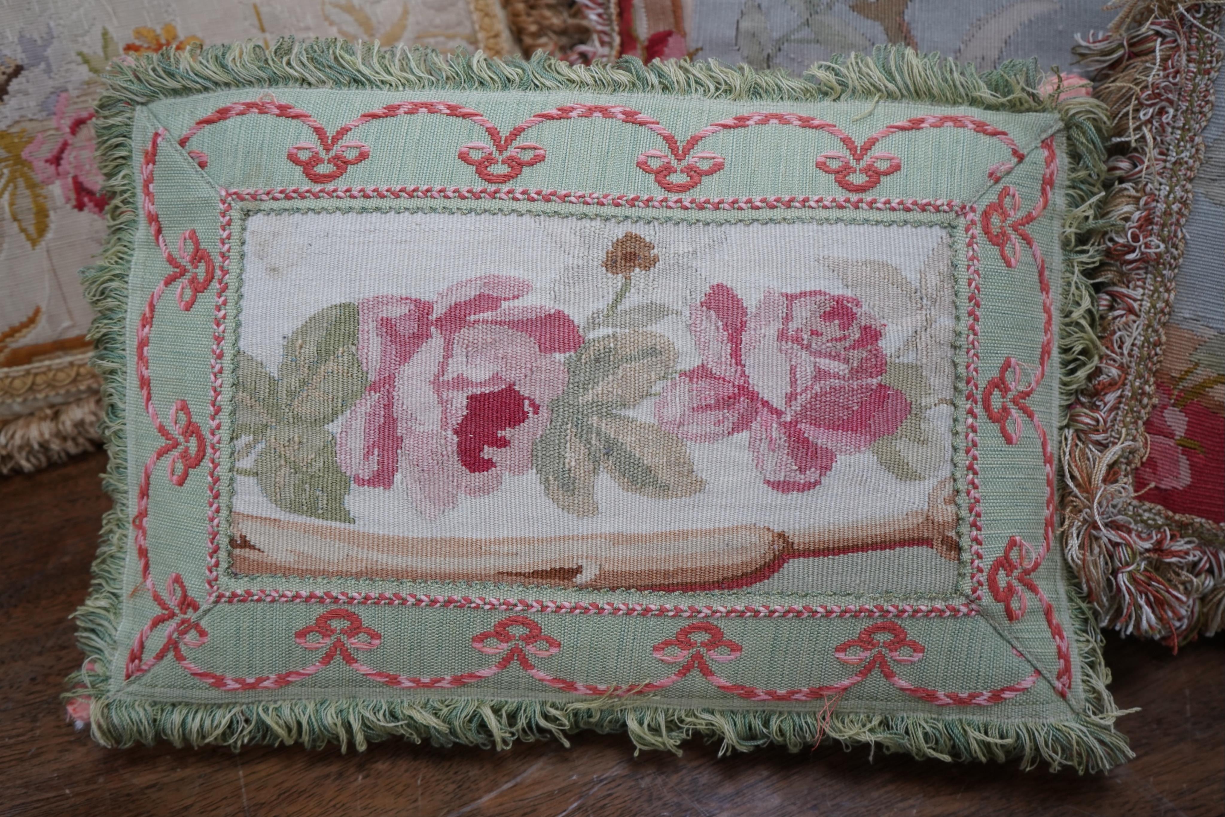 Seven 19th century cushions. Three Aubusson tapestry cushions and two machine Aubusson cushions, together with two floral wool worked cushions, all with decorative fringing. Largest 40cm x 45cm. condition - three are wor